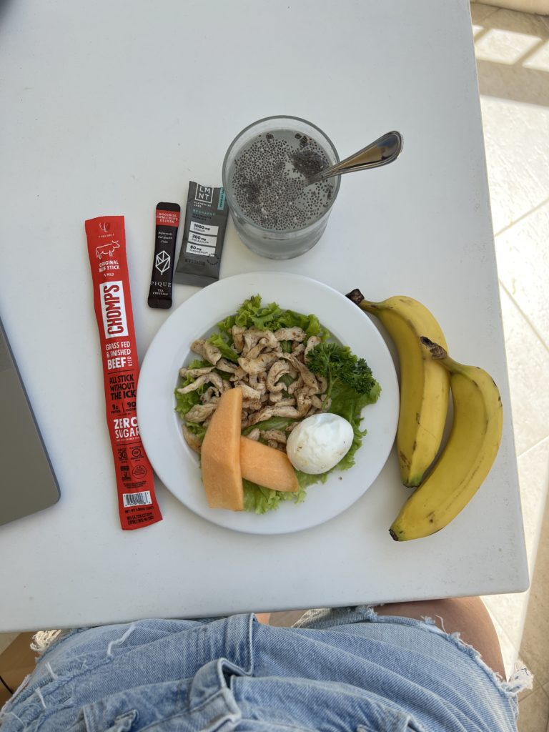 A typical lunch we ate in the DR — grilled chicken, hard boiled egg, bananas, chomps beef jerkey, LMNT electrolyte packs, and Pique Tea