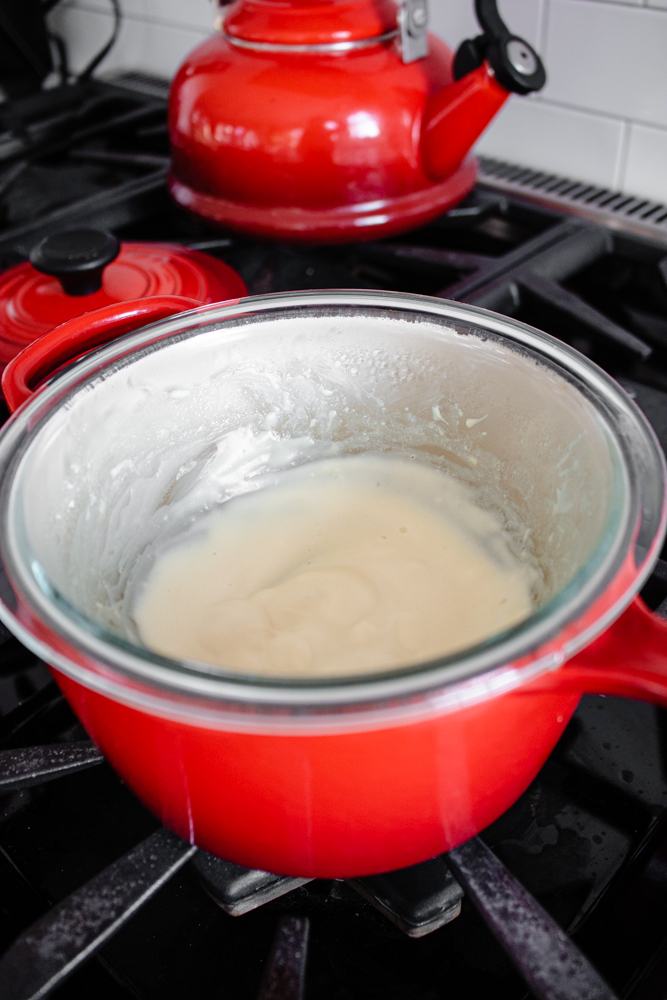 A double boiler with melted cream cheese and maple syrup.