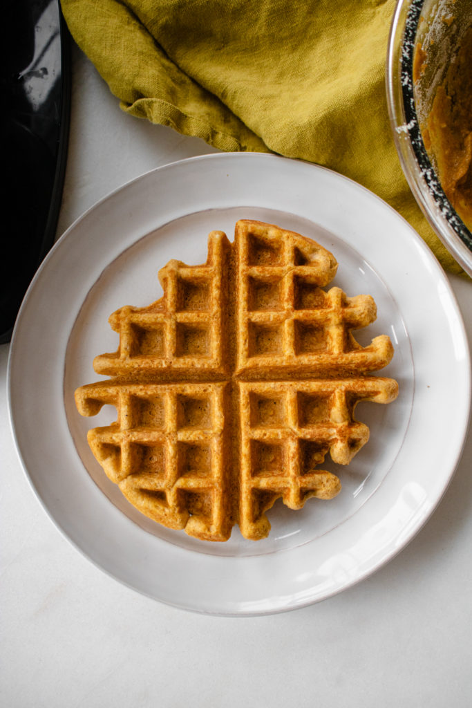sweet potato protein waffled on a white plate with a yellow towel