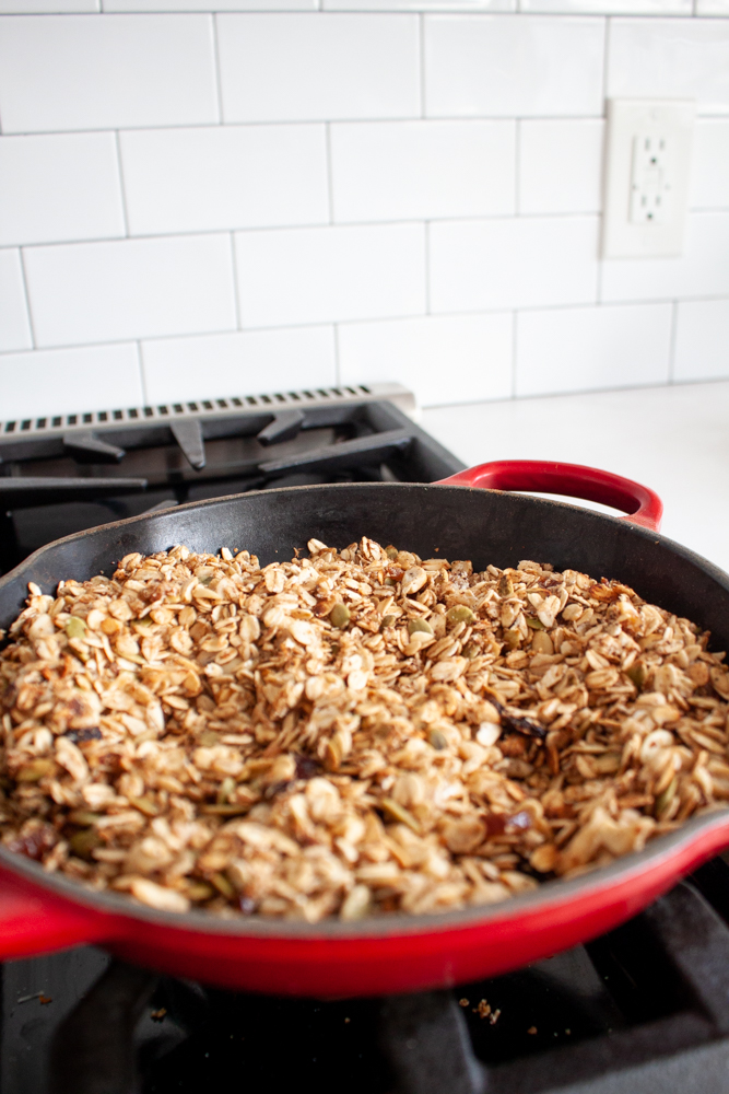 granola in a red skillet on a stovetop
